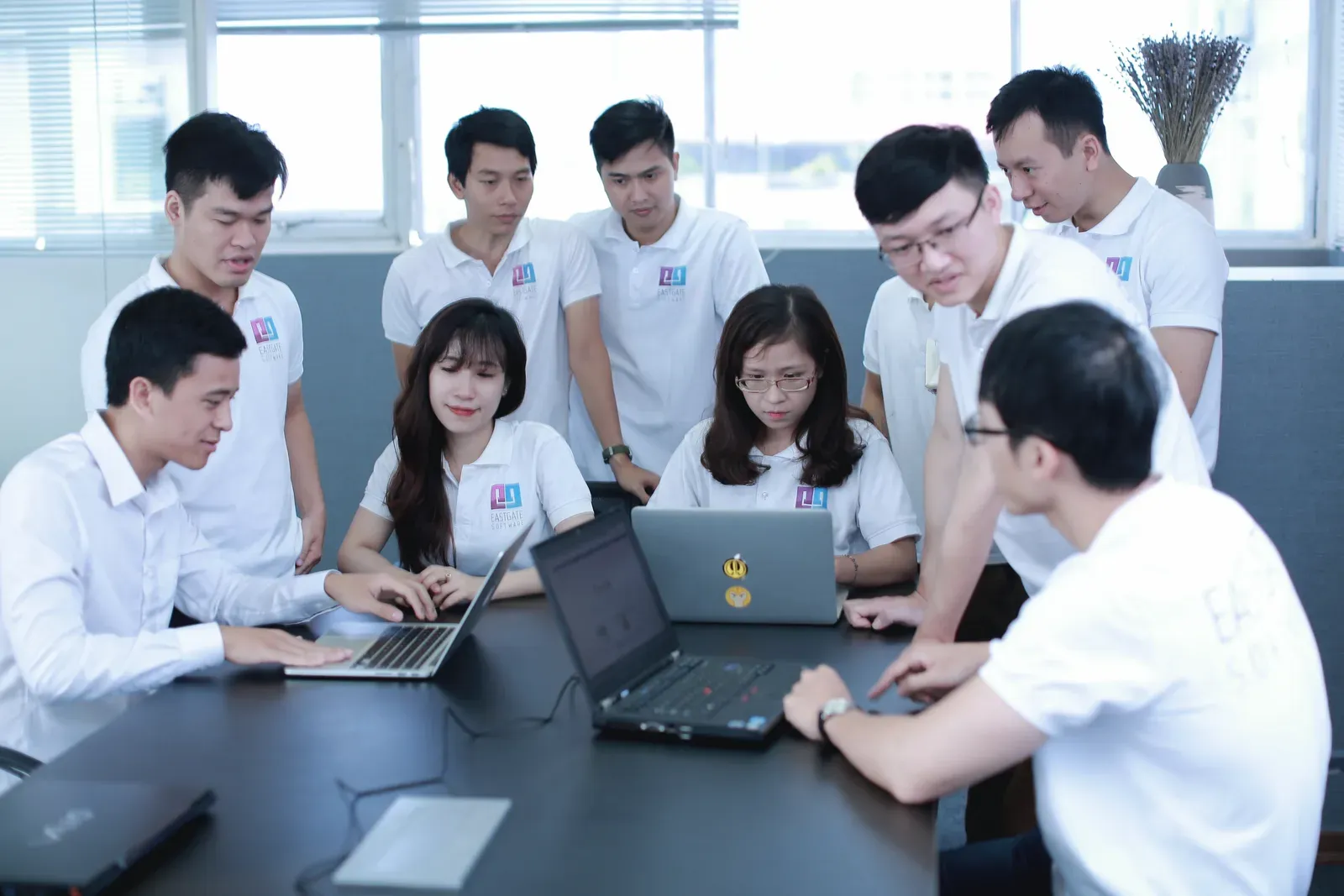 Eastgate engineers around a table with laptops, deciding the next step together
