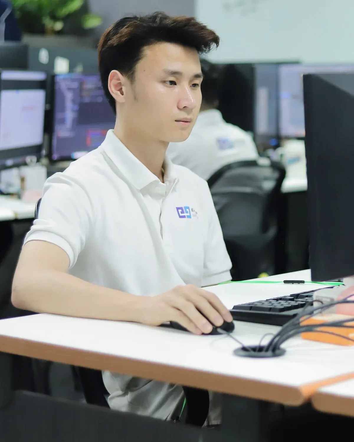 An engineer working at his desk in front of two screens