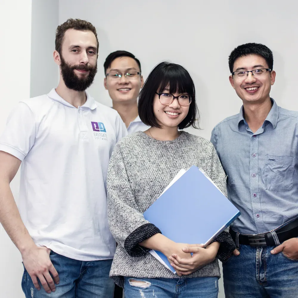 Four Eastgate engineers standing together, one holding a blue project folder