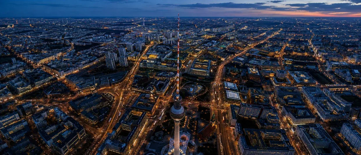 Aerial view of a city road network at dusk with illuminated traffic corridors