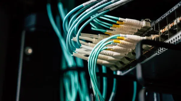 Fibre-optic patch cables connected to a network switch in a server rack