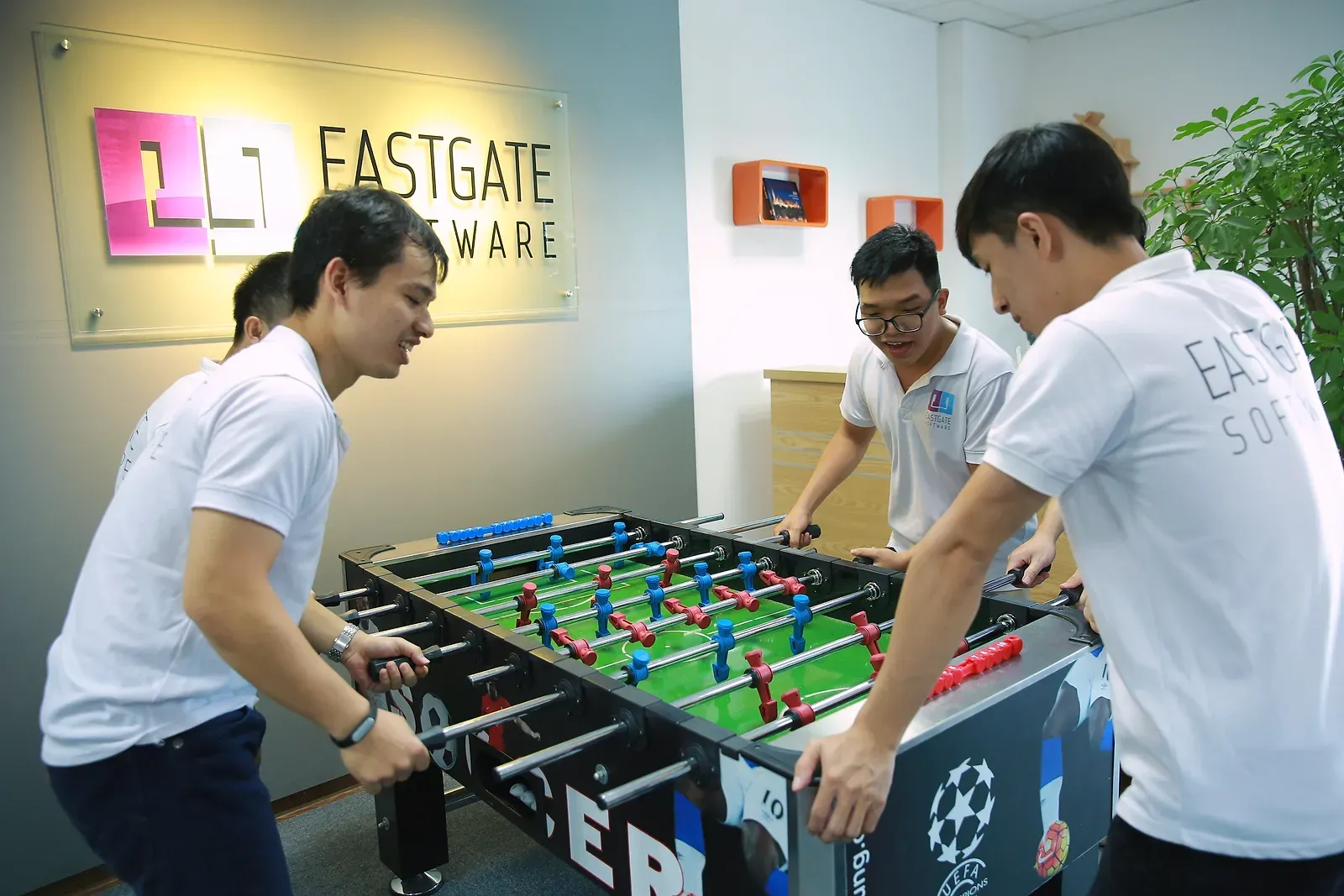 Colleagues playing table football in the Eastgate office